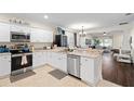 Open kitchen with white cabinetry, stainless appliances, and view into the connected living space at 1410 25Th N St, St Petersburg, FL 33713