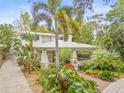 Attractive home with a metal roof, lush landscaping, brick walkway, and welcoming front porch at 1805 W Richardson Pl, Tampa, FL 33606