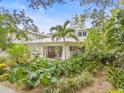 Beautiful home with a metal roof, lush landscaping, brick walkway, and welcoming front porch at 1805 W Richardson Pl, Tampa, FL 33606