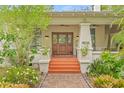 Charming entryway with double wood doors, orange steps, and lush landscaping at 1805 W Richardson Pl, Tampa, FL 33606