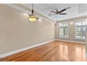 Inviting bedroom featuring hardwood floors, tray ceiling, and abundant natural light from shuttered windows at 2226 Soho Bay Ct, Tampa, FL 33606