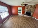 Living room with hardwood floors, stone fireplace, ceiling fan, and a window offering natural light at 3206 Las Brisas Dr, Riverview, FL 33578