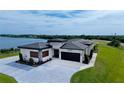 Stunning aerial view of a modern home with a two-car garage and landscaping near the lake at 3610 Gulf City Rd, Ruskin, FL 33570