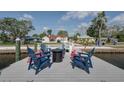 Relaxing dock area with comfortable red and blue chairs arranged around a modern, round fire pit at 4151 Sunrise S Dr, St Petersburg, FL 33705