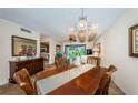 Elegant dining room with dark wood furniture, chandelier, and a view of the living area and golf course at 6077 Bahia Del Mar Blvd # 123, St Petersburg, FL 33715