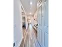 Bright and airy hallway featuring stylish flooring, modern decor, and easy access to living spaces at 6293 Bradford Woods Dr, Zephyrhills, FL 33542