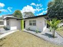 Well-kept home exterior with a lush green lawn and stylish landscaping at 7101 N 9Th St, Tampa, FL 33604