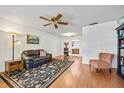 Inviting living room featuring hardwood floors and a cozy seating area with natural light at 7234 Riverwood Blvd, Tampa, FL 33615