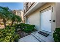 Cozy townhouse entrance featuring 'Home' welcome mat, tropical plants, and a convenient doorbell at 805 100Th N Ave, St Petersburg, FL 33702