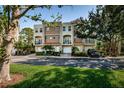Charming multi-story townhouse complex with well-manicured lawn, lush trees, and brick-paved driveways at 805 100Th N Ave, St Petersburg, FL 33702