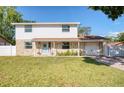 Inviting two-story home with a manicured lawn, stone accents, and a quaint front porch at 8798 94Th St, Seminole, FL 33777