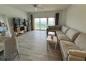 Bright living room with ocean view balcony access, comfortable sofa, and modern decor at 880 Mandalay Ave # C704, Clearwater Beach, FL 33767