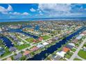 Stunning aerial view of waterfront community with canals, beautiful homes and manicured lawns leading out to a bay at 890 Coronado Dr, Punta Gorda, FL 33950