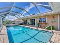 Refreshing pool with screened enclosure, outdoor seating, and bar area, ideal for relaxation and entertaining guests at 890 Coronado Dr, Punta Gorda, FL 33950