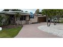 Inviting single-story house featuring a brick-paved driveway and tropical landscaping at 997 Boca Ciega Isle Dr, St Pete Beach, FL 33706