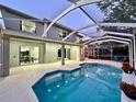 Screened in in-ground pool with view of the house and rear entrance to home with patio and seating area at 10130 Deercliff Dr, Tampa, FL 33647
