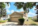 Two-story home showcasing a two-car garage in a suburban setting with lush landscaping at 12604 Montford Ln, Riverview, FL 33579