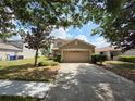 Traditional two-story house with attached garage and mature trees in a desirable neighborhood at 12604 Montford Ln, Riverview, FL 33579