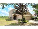 Inviting two-story home with a well-manicured lawn, mature tree and attached two-car garage at 12604 Montford Ln, Riverview, FL 33579