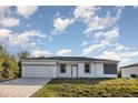 Charming single-story home with well-kept lawn and an attached two-car garage at 13451 Kaplan Ter, Port Charlotte, FL 33981