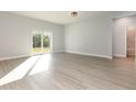 Bright, open living space with sliding glass doors and modern light gray flooring at 13451 Kaplan Ter, Port Charlotte, FL 33981
