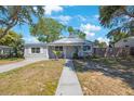 Inviting single-story home with a well-manicured lawn and sidewalk leading to the front entrance at 1422 Pinebrook Dr, Clearwater, FL 33755