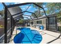Backyard featuring a sparkling private pool with a screened enclosure and outdoor seating area at 1422 Pinebrook Dr, Clearwater, FL 33755
