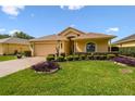 Attractive home with manicured lawn, colorful plants, and a two-car garage at 17425 Eagle Trace Dr, Brooksville, FL 34604