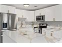 Bright kitchen features white cabinets, stainless steel appliances and island with quartz countertops at 1843 38Th S St, St Petersburg, FL 33711
