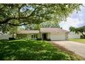 A lovely home with stone accents and a two-car garage, complemented by a well-kept lawn and mature trees at 2004 Chickwood Ct, Tampa, FL 33618