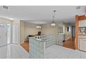 Open-concept living space with tile and wood flooring, glass block features, and neutral paint at 2023 Golfview Dr # 2023, Tarpon Springs, FL 34689