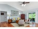 Cozy living room with hardwood floors, neutral paint, comfortable furniture, ceiling fan and sliding glass doors at 206 147Th E St, Bradenton, FL 34212
