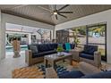 Inviting covered patio featuring comfortable seating, a ceiling fan, and views of the outdoor pool area at 2109 N Jamaica St, Tampa, FL 33607