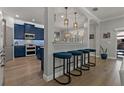 Stylish kitchen featuring blue cabinets, modern appliances, a breakfast bar with seating, and pendant lighting at 2109 N Jamaica St, Tampa, FL 33607