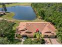 Aerial view of home, near lake, surrounded by lush greenery at 2471 New Haven Cir, Sun City Center, FL 33573