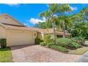 Side view of an inviting single story home with an attached garage and a brick paved driveway at 2471 New Haven Cir, Sun City Center, FL 33573