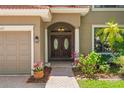 Inviting front entrance with a double wooden door, lush landscaping, and a cozy, welcoming feel at 2671 Lakebreeze S Ln, Clearwater, FL 33759