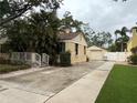Side view featuring a home with detached garage and long driveway, accented by lush landscaping at 2923 W Coachman Ave, Tampa, FL 33611