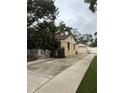 Home with detached garage and long driveway; a white fence and green lawn complete the scene at 2923 W Coachman Ave, Tampa, FL 33611