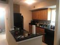 A kitchen featuring wood cabinets and black appliances at 3206 W Azeele St # 226, Tampa, FL 33609