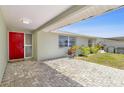 Covered front porch with tiled flooring and a bright red front door at 3654 Warbler Dr, New Port Richey, FL 34652