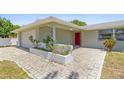 Inviting front porch with brick pavers and a red front door at 3654 Warbler Dr, New Port Richey, FL 34652