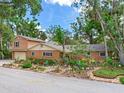 Charming brick home featuring a vibrant front yard garden with unique decorative elements and a stone path at 402 S Barbara Ln, Tampa, FL 33609