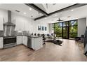 A modern open-concept living room with sleek kitchen, black steel beams, and expansive windows at 4118 Gauge Line Loop, Tampa, FL 33624
