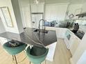 The kitchen features new appliances, white cabinets, and a black countertop island with seating at 4141 Bayshore Blvd # 1103, Tampa, FL 33611