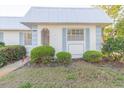 Inviting home with a metal roof, blue trim, and well-maintained landscaping at 4235 Tamargo Dr # 4235, New Port Richey, FL 34652