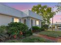 Charming single-story home with a metal roof, pretty landscaping, and blue shutters at dusk at 4235 Tamargo Dr # 4235, New Port Richey, FL 34652