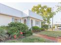 Charming home featuring a metal roof, blue shutters, and colorful landscaping at 4235 Tamargo Dr # 4235, New Port Richey, FL 34652