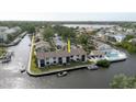 Wide aerial shot of canal-front condos featuring community pool and boat docks, surrounded by lush greenery at 428 Moorings Cove Dr # 7F, Tarpon Springs, FL 34689