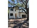Modern two-story home featuring a stucco exterior, large windows, and an attached two-car garage at 4618 W Kensington Ave, Tampa, FL 33629
